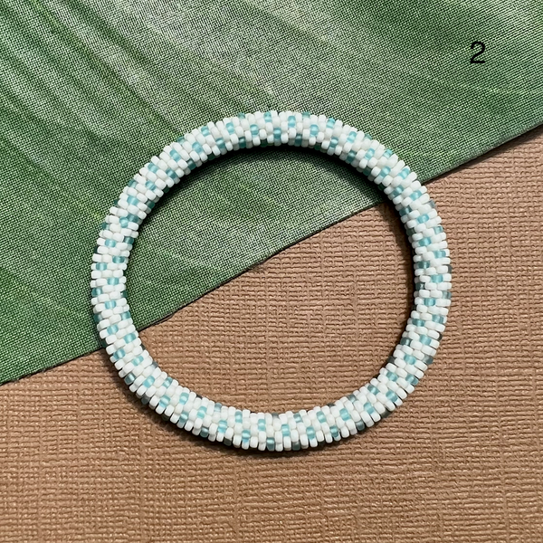 Cream glass seed beads are crocheted with teal polka dots. Stackable bangle bracelets are comfortable enough to wear everyday.