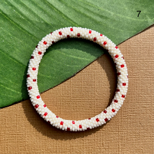 White glass sead beads are crocheted into a beaded bangle with red polka dots. Beaded bangle bracelets can be rolled on and paired with other jewelry.