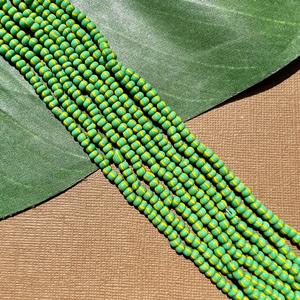 Czech green with yellow stripe size 6 seed bead - shown flat