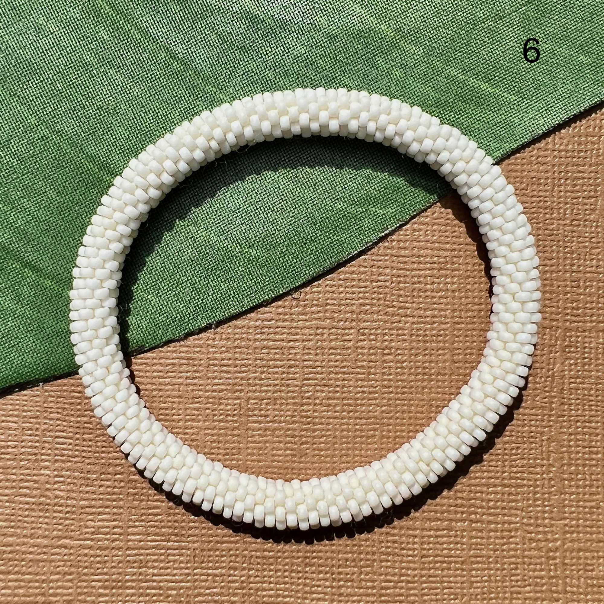 Creamy white beaded bangle.