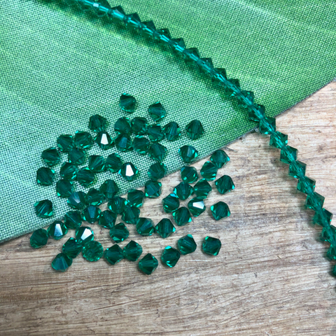 Vintage crystal emerald green 4mm bi-cones. 