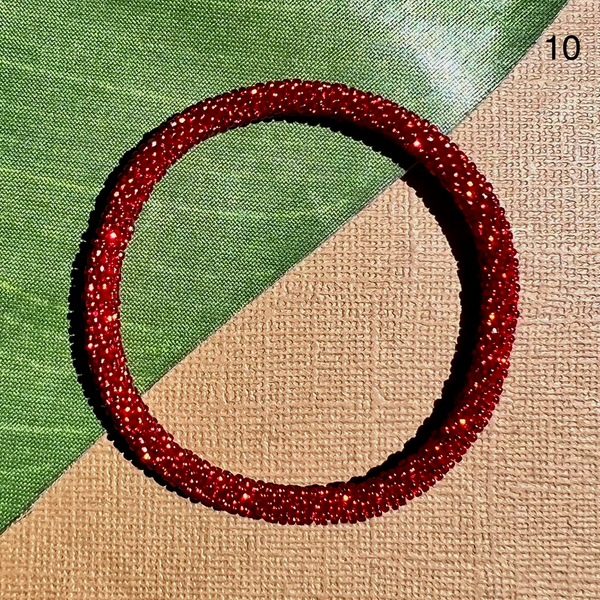 Translucent red glass seed beads make up this beaded bangle bracelet.  Beaded bangle fits most, can be rolled on. Pairs well with other beaded bangles and bracelets.
