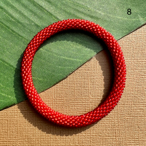 Red seed beads make up this beaded bracelet.  It can be rolled on and paired with other beaded bangles and other jewelry. 