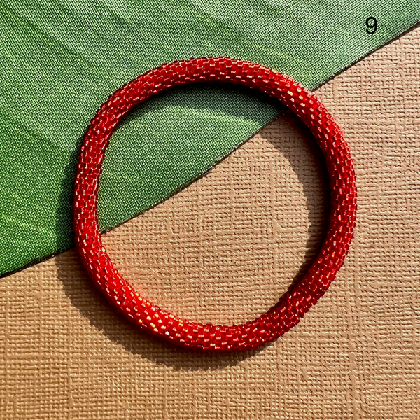 Red glass seed beads make up this solid beaded bangle bracelet.